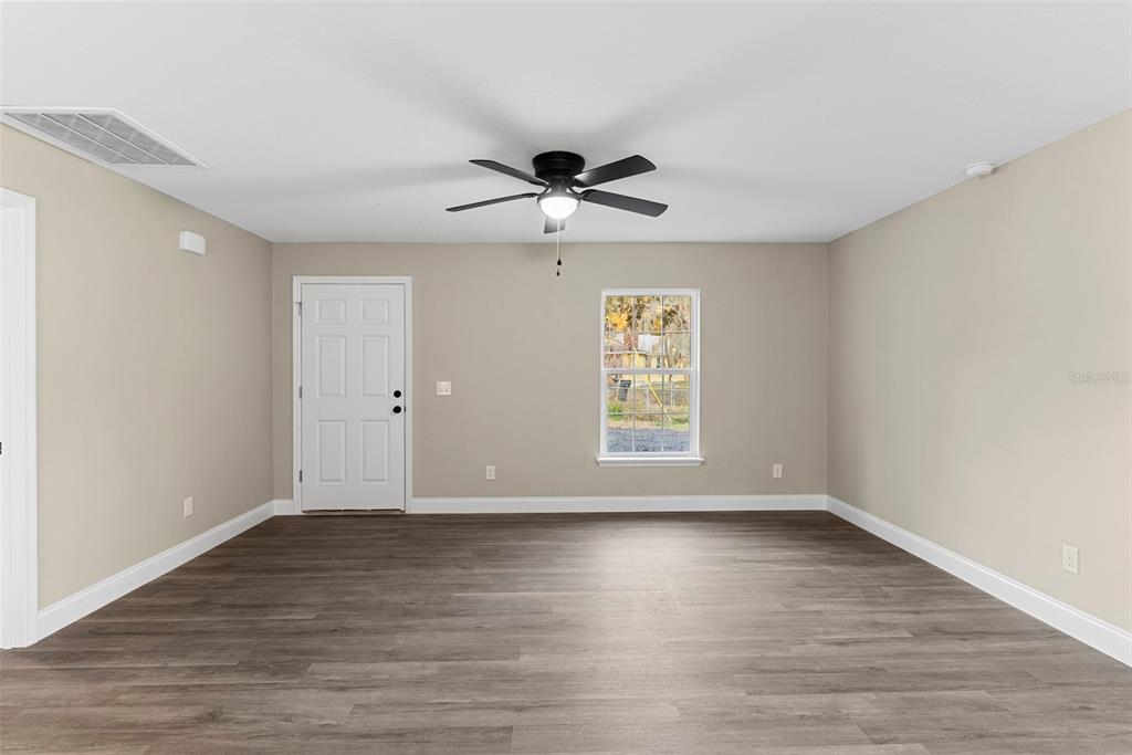 603 Moose Lodge Road, Unit A Bartow, FL 33830 - Photo 22 of 22 an empty room with wooden floor chandelier fan and windows