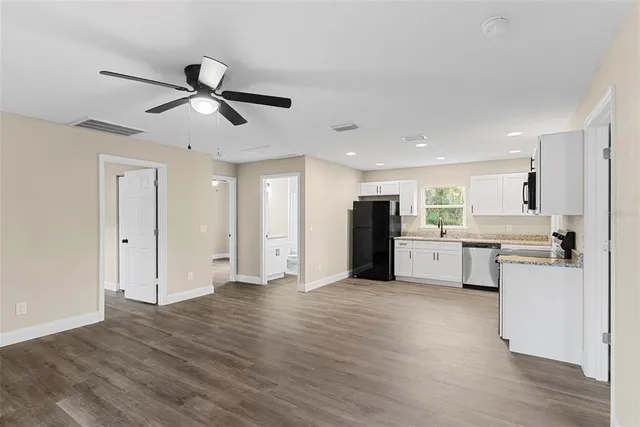 a view of a kitchen with wooden floor and electronic appliances