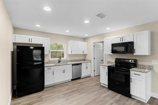 a kitchen with a sink stainless steel appliances and cabinets