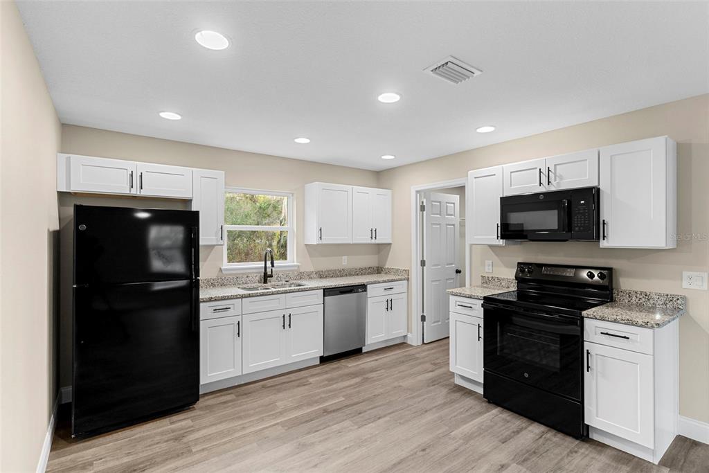 603 Moose Lodge Road, Unit A Bartow, FL 33830 - Photo 9 of 22 a kitchen with a sink stainless steel appliances and cabinets
