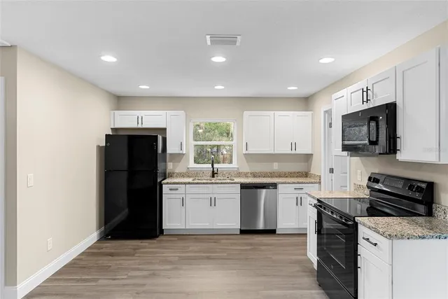 a kitchen with stainless steel appliances granite countertop a refrigerator stove microwave and sink