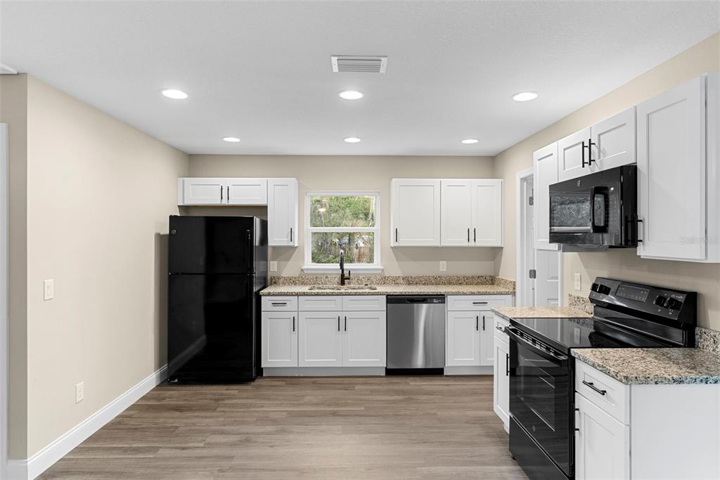 603 Moose Lodge Road, Unit A Bartow, FL 33830 - Photo 10 of 22 a kitchen with stainless steel appliances granite countertop a refrigerator stove microwave and sink
