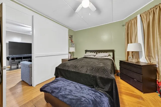 a bedroom with a bed and a flat tv screen on dresser