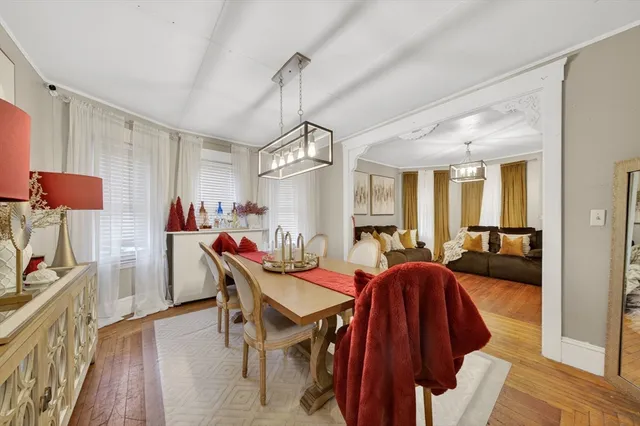 a view of a dining room and livingroom with furniture wooden floor a chandelier