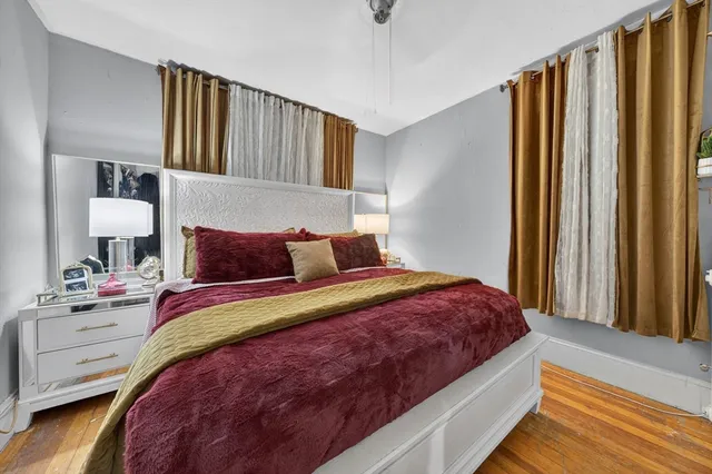 a bedroom with bed and wooden floor