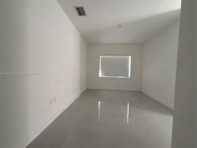 an empty room with a empty space and windows