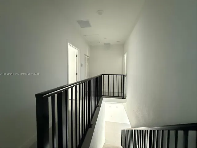 a view of a hallway with wooden floor and a window