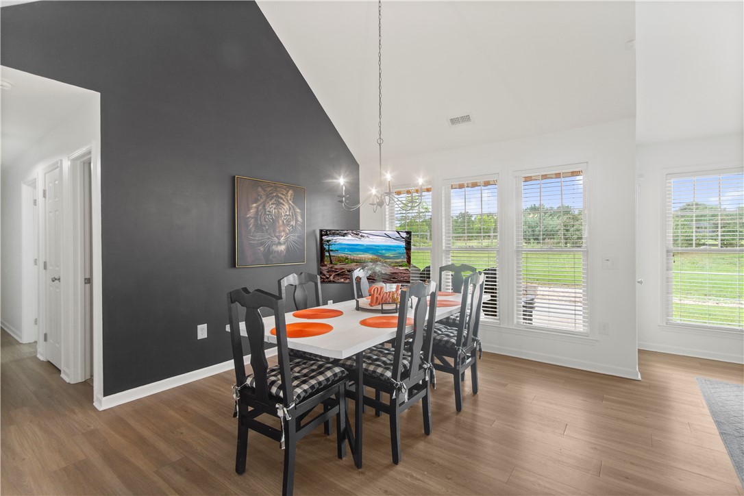 2900 Highway 187 Anderson, SC 29626 - Photo 16 of 41 An open dining area features high ceilings, hardwood flooring, and ample natural light through multiple windows.