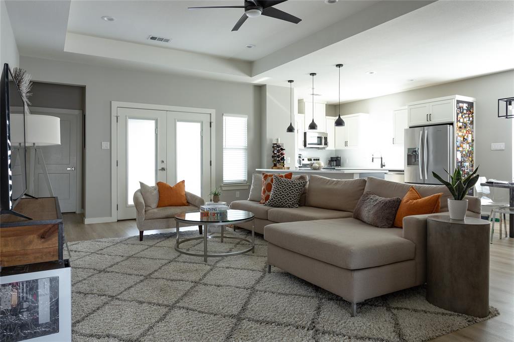1108 Claude Street Dallas, TX 75203 - Photo 5 of 17 Open-concept living space featuring wood-finish flooring and a tray ceiling with a ceiling fan