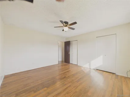 a view of a big room with wooden floor and a ceiling fan