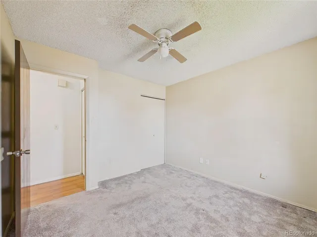 an empty room with closet and ceiling fan
