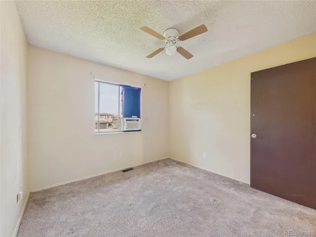 a view of a room with an empty space and a ceiling fan