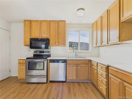 a kitchen with stainless steel appliances a stove a sink and a microwave