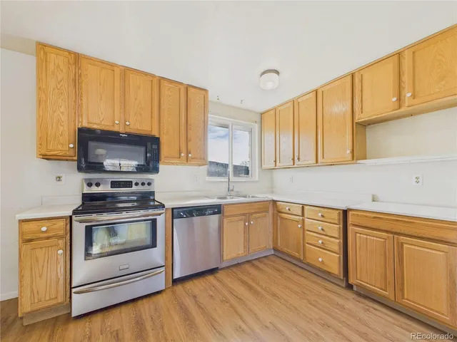 a kitchen with stainless steel appliances granite countertop a stove a sink and a microwave