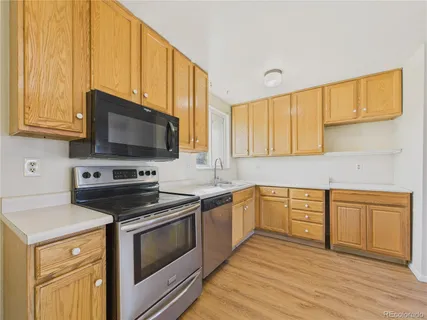 a kitchen with stainless steel appliances wooden cabinets and a stove top oven