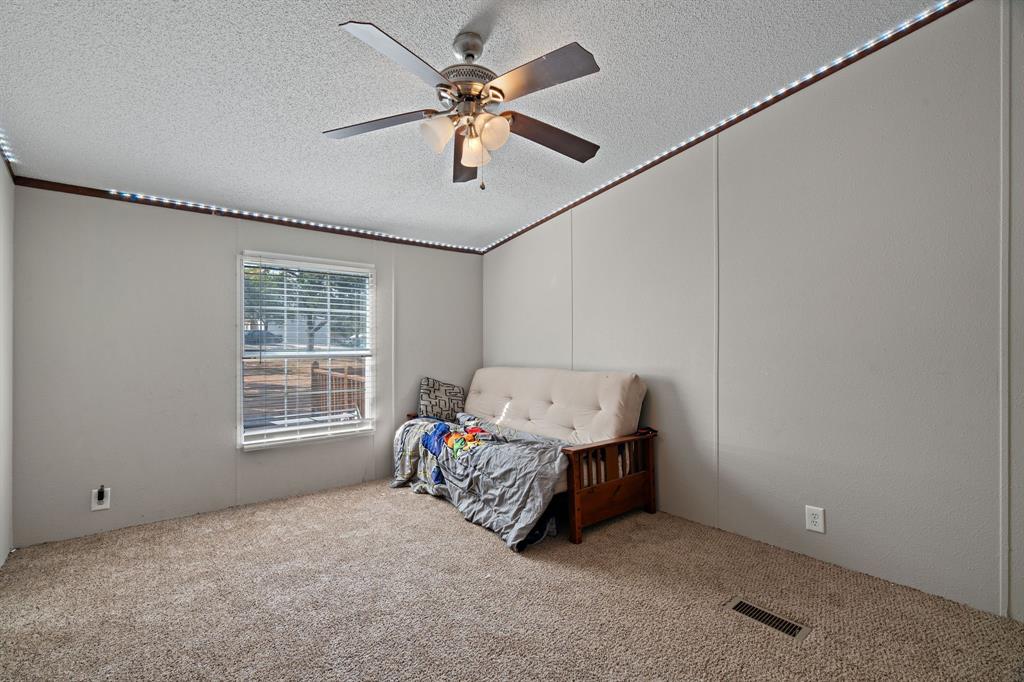 2005 Atticus Court Springtown, TX 76082 - Photo 11 of 15 a spacious bedroom with a bed and a chandelier