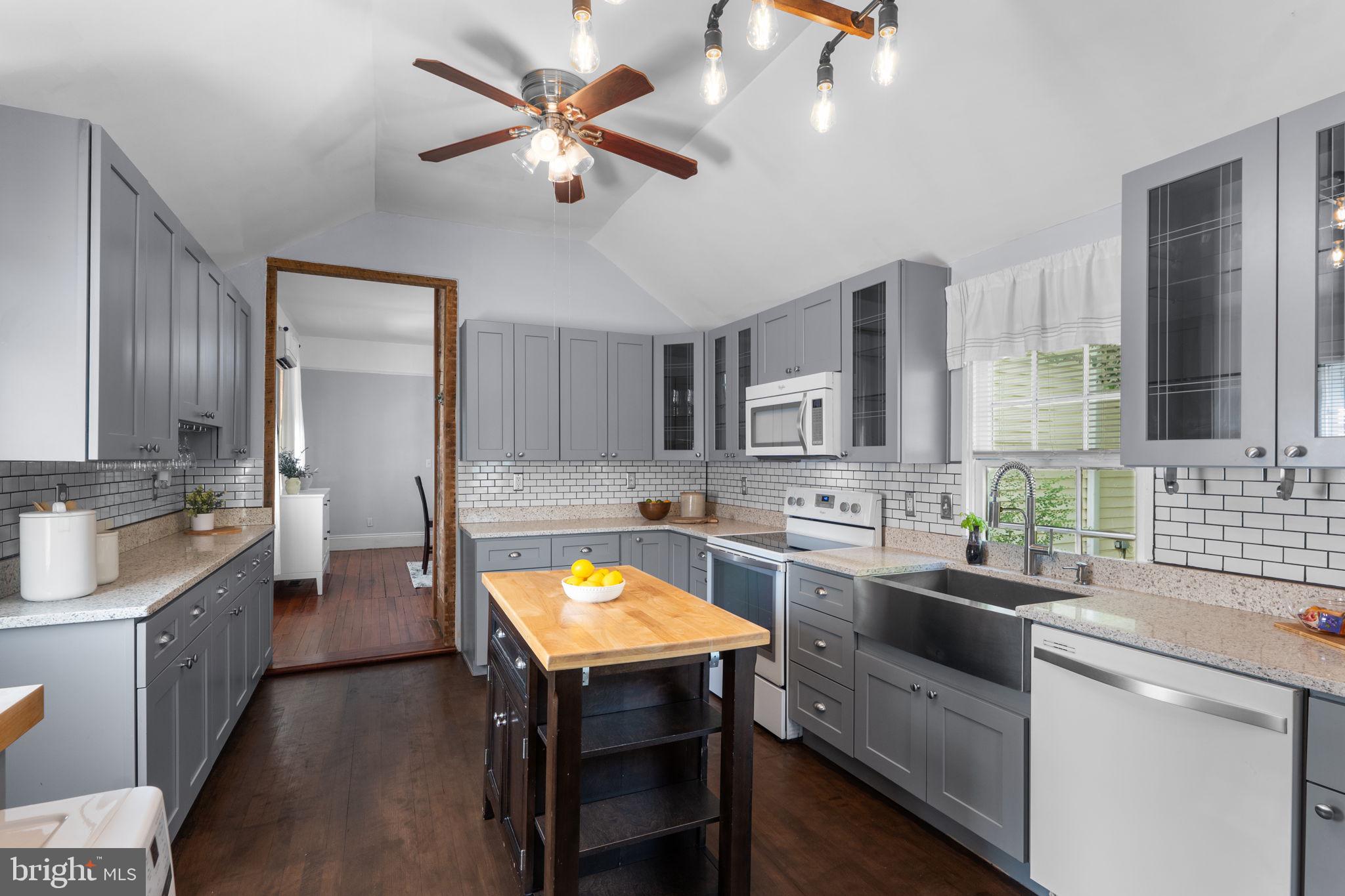 10007 Croom Road Upper Marlboro, MD 20772 - Photo 21 of 134 a kitchen with a stove a sink and wooden cabinets