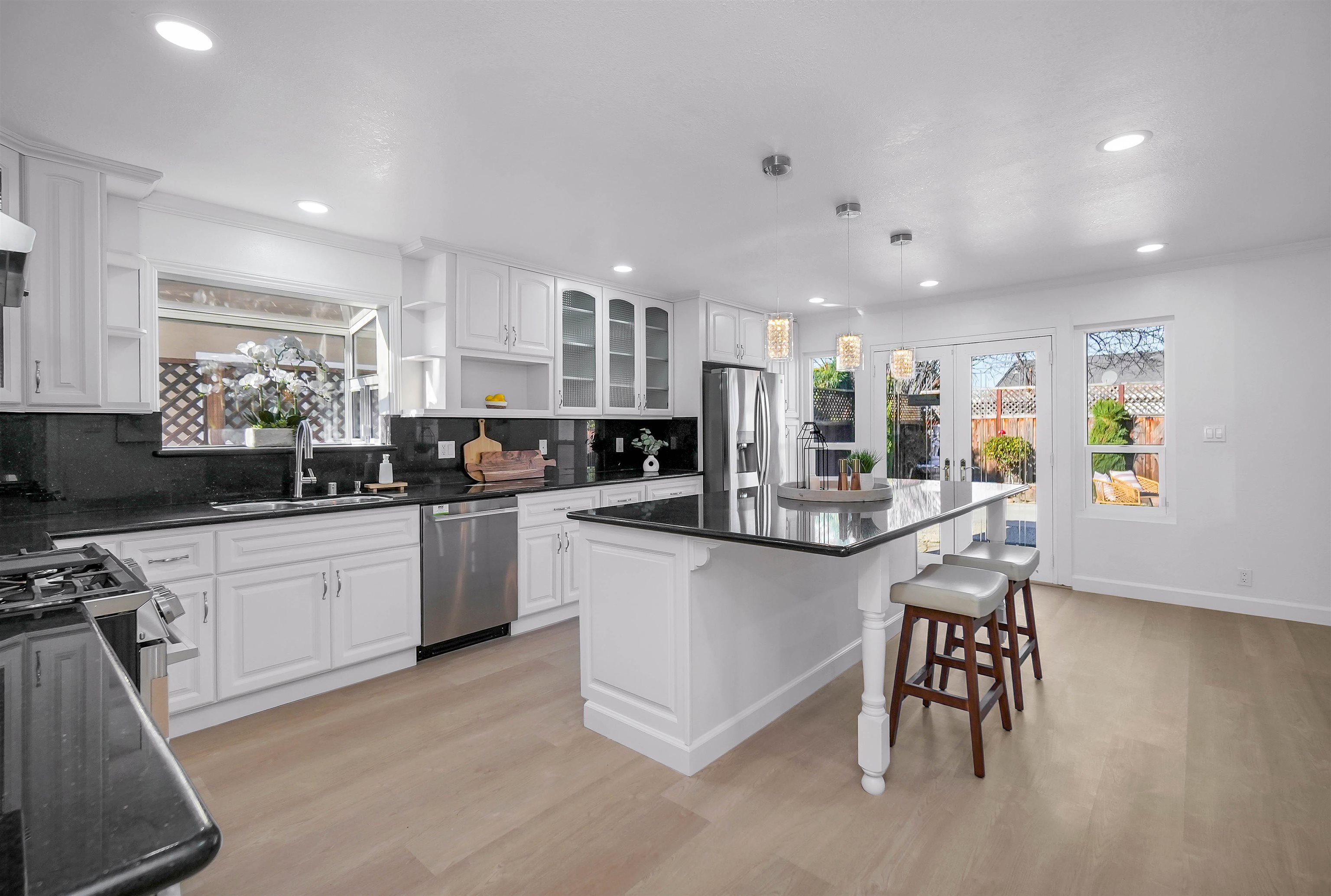 3159 Rowe Place Fremont, CA 94536 - Photo 45 of 59 a kitchen with stainless steel appliances granite countertop a stove top oven a sink dishwasher a refrigerator and white cabinets with wooden floor