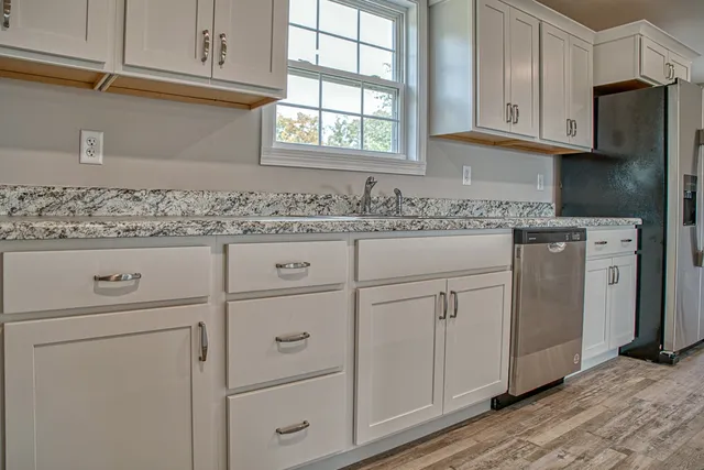 a kitchen with granite countertop cabinets appliances and a window