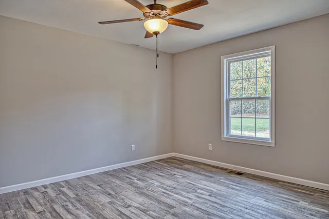 wooden floor in an empty room with a window
