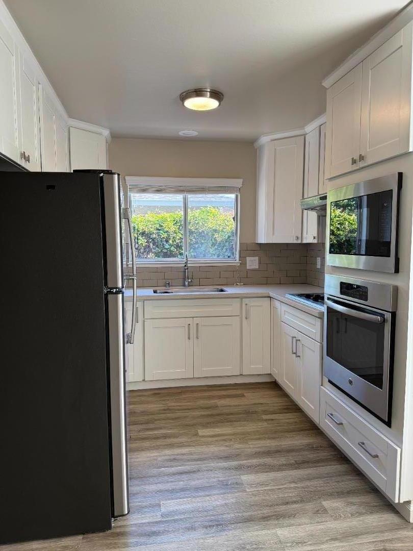 805 Devoto Street Mountain View, CA 94041 - Photo 3 of 3 a white kitchen with granite countertop stainless steel appliances and a refrigerator