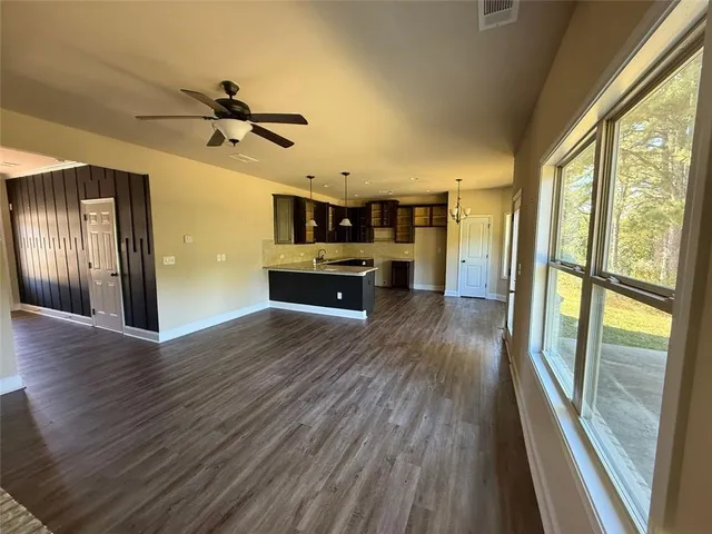 a view of a living room hardwood floor and a kitchen