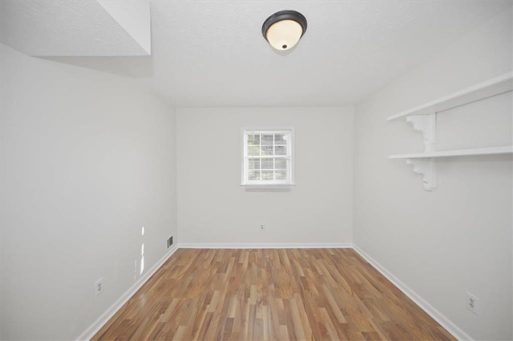 1496 Cherry Hill Road Southwest Conyers, GA 30094 - Photo 10 of 32 a view of a room with wooden floor and white walls