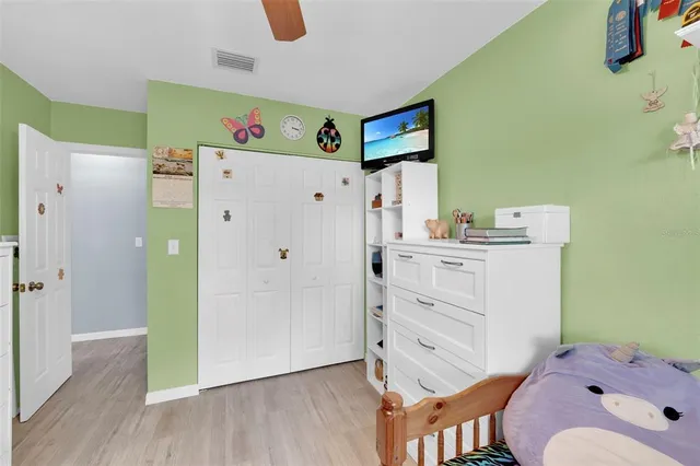 a bedroom with a bed and wooden floor