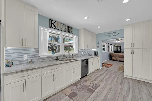 a kitchen with granite countertop a sink and cabinets