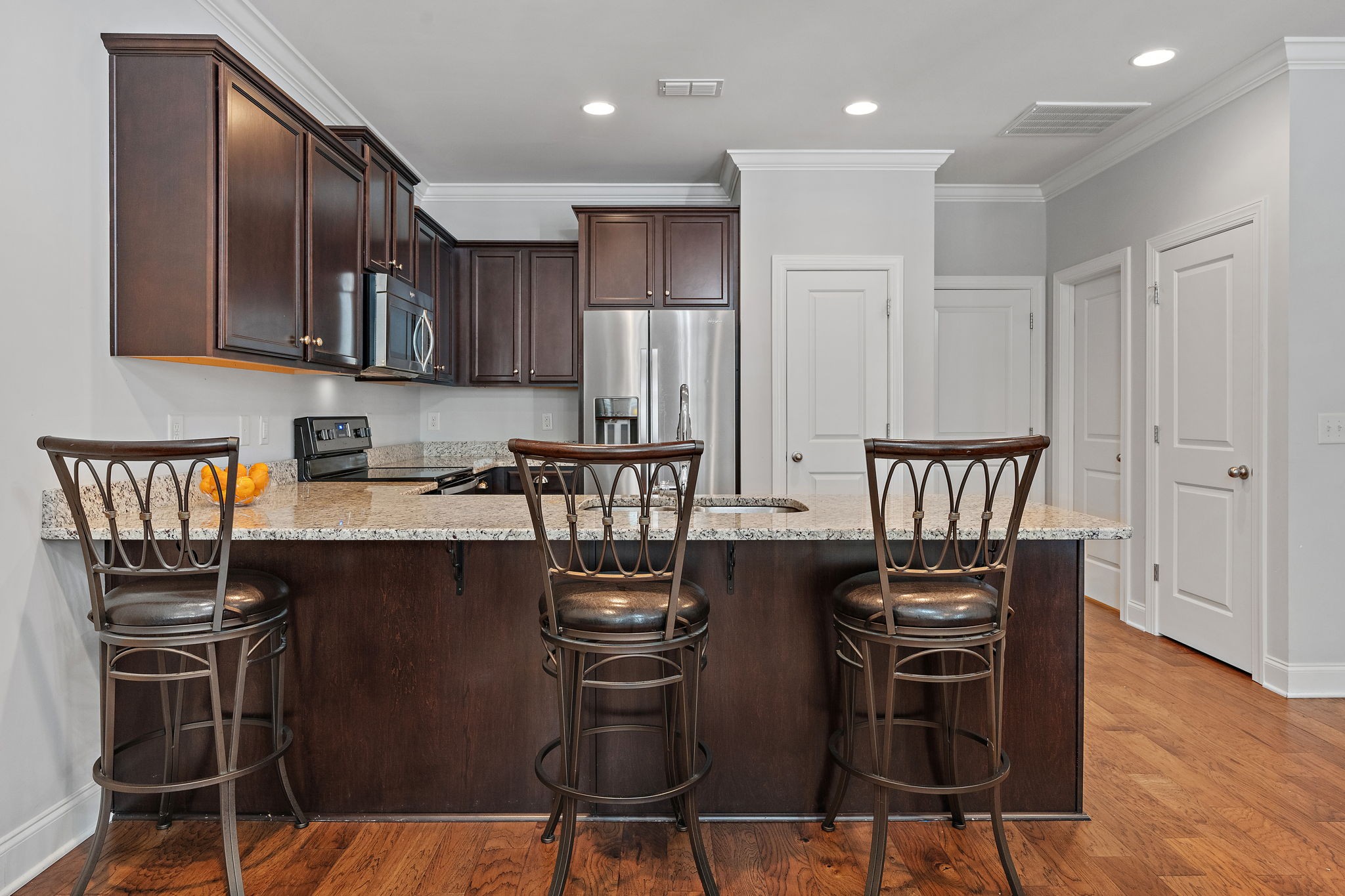 916 Gateway Court Franklin, TN 37069 - Photo 7 of 26 a kitchen with stainless steel appliances granite countertop a stove top oven a dining table and chairs with wooden floor