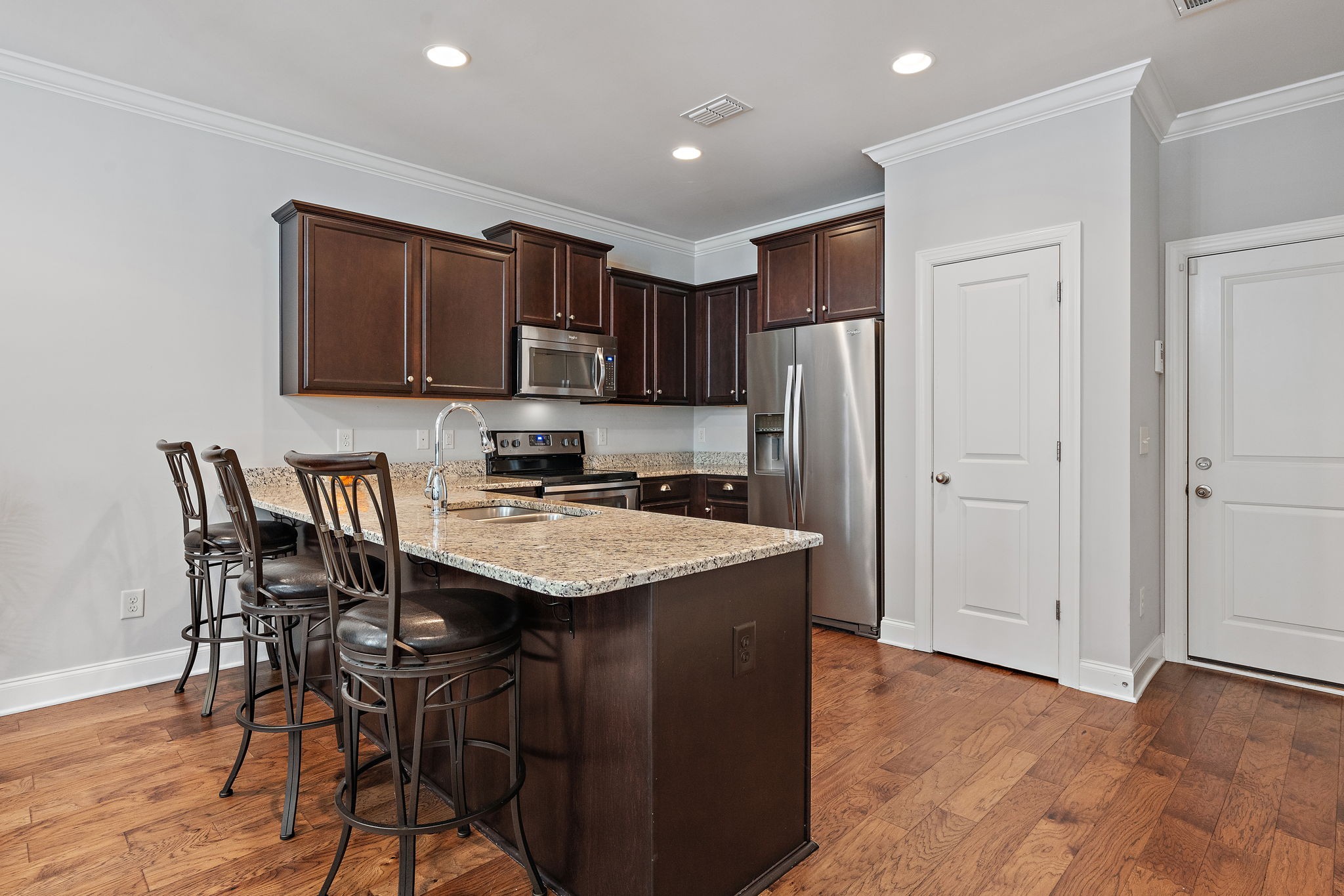 916 Gateway Court Franklin, TN 37069 - Photo 8 of 26 a kitchen with stainless steel appliances granite countertop a stove a refrigerator a sink a dining table and chairs with wooden floor