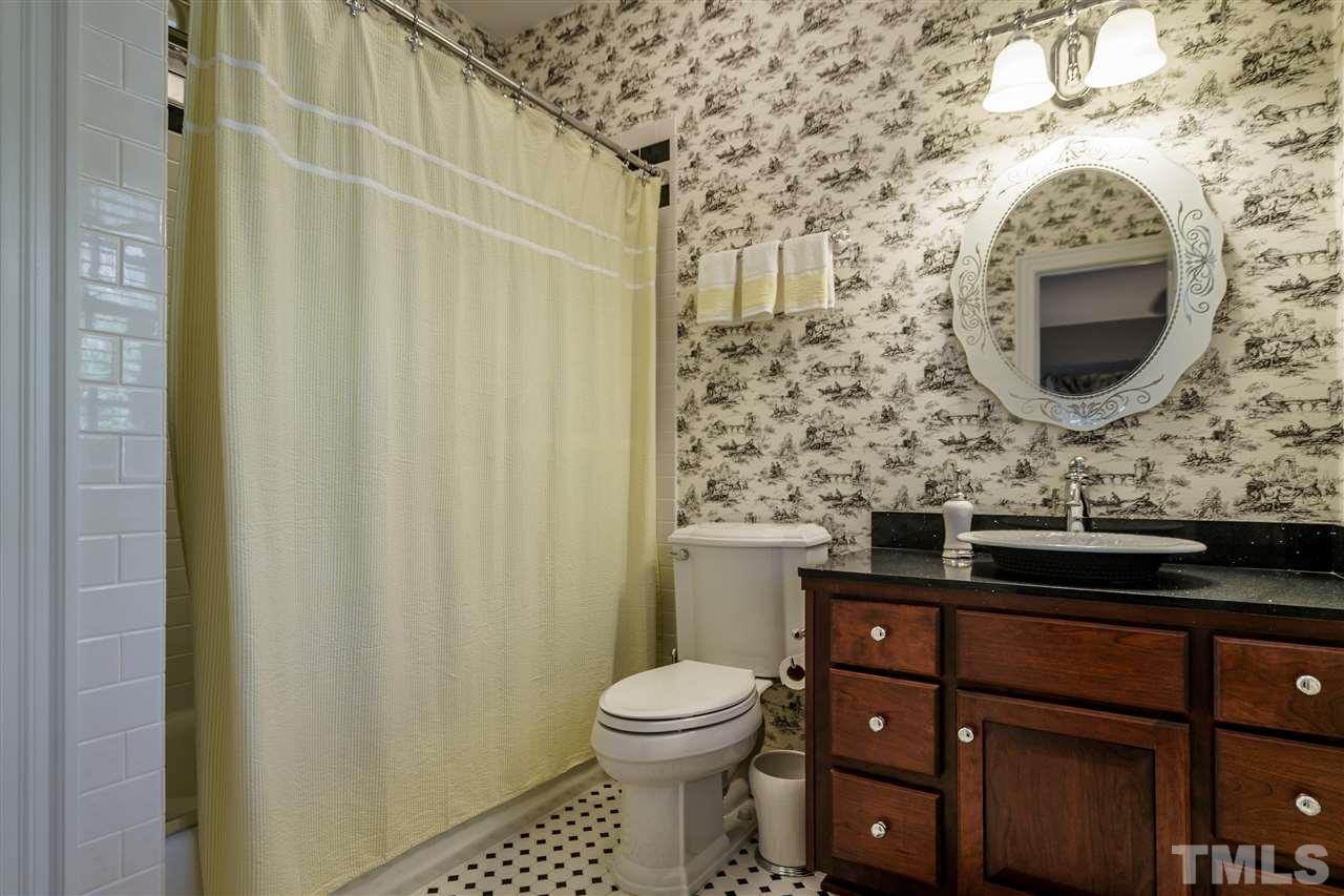 1028 Mersey Lane Raleigh, NC 27615 - Photo 14 of 30 Private Guest Bath with raised bowl sink, subway tile tub/shower with Rohl fixtures and tile floors.