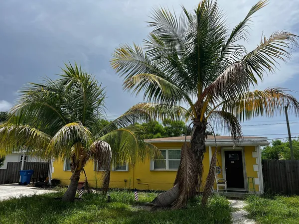 a view of multiple house with a yard and palm trees
