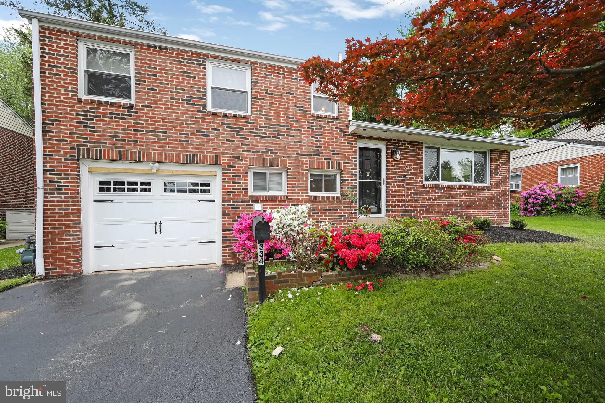 334 Parham Road Springfield, PA 19064 - Photo 4 of 41 a front view of house and yard with beautiful flowers and green space