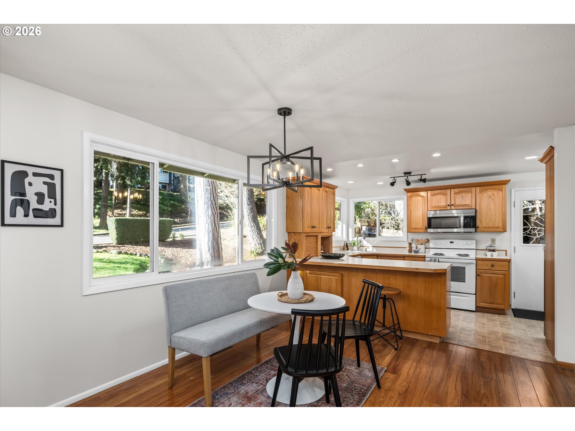 195 Coachman Drive Eugene, OR 97405 - Photo 9 of 34 a dining room with furniture a chandelier and wooden floor
