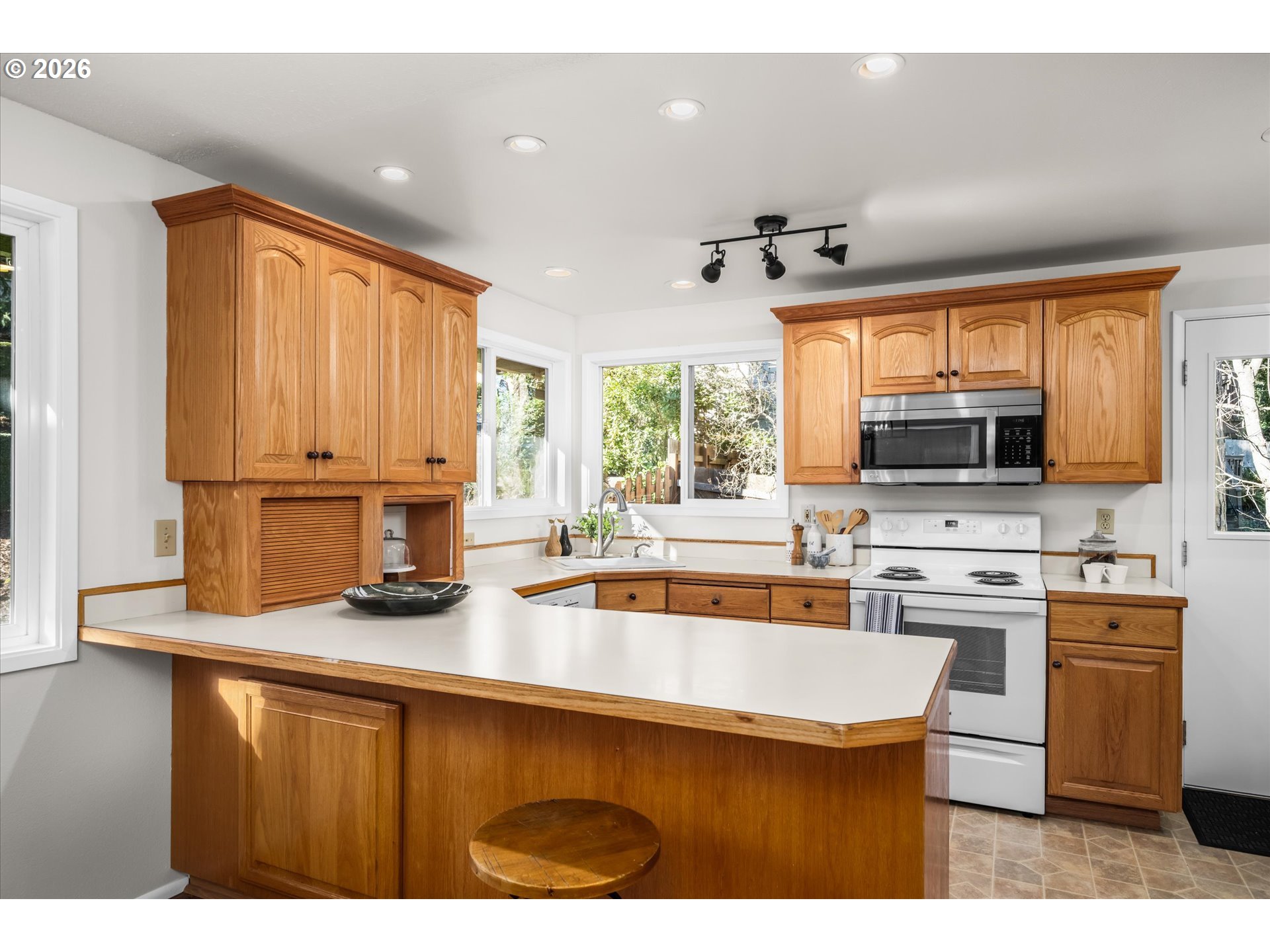 195 Coachman Drive Eugene, OR 97405 - Photo 10 of 34 a kitchen with kitchen island granite countertop a sink cabinets and window
