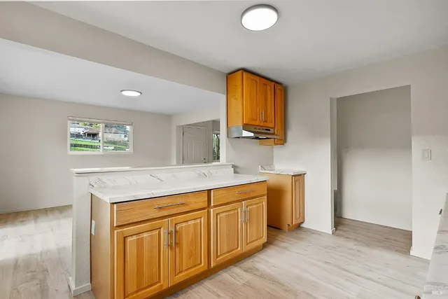 a kitchen with stainless steel appliances granite countertop a sink and a stove with wooden floor