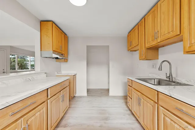 a kitchen with stainless steel appliances granite countertop a sink and dishwasher next to a window
