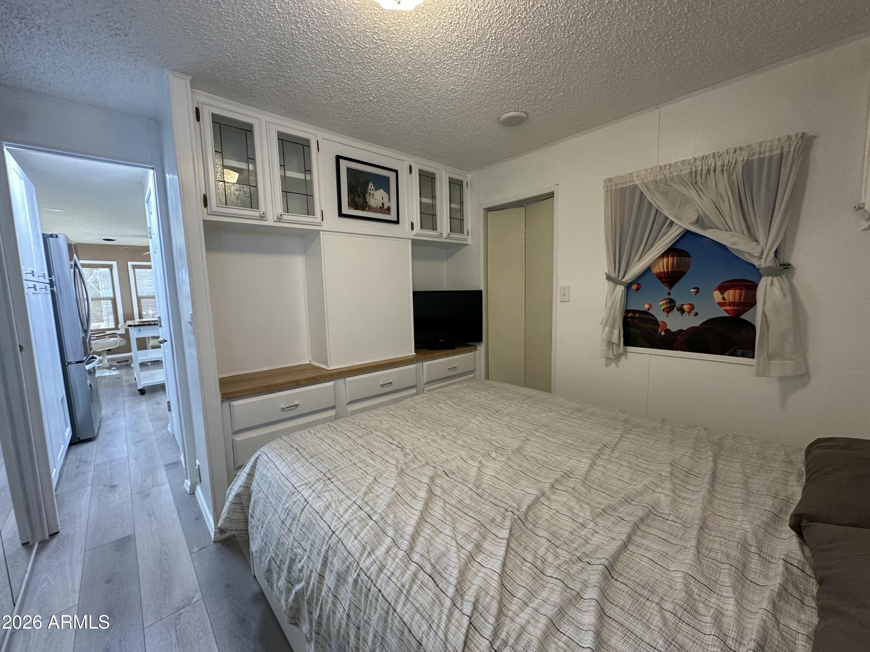 111 South Greenfield Road, Unit 575 Mesa, AZ 85206 - Photo 4 of 14 a bedroom with a bed and a painting on the wall