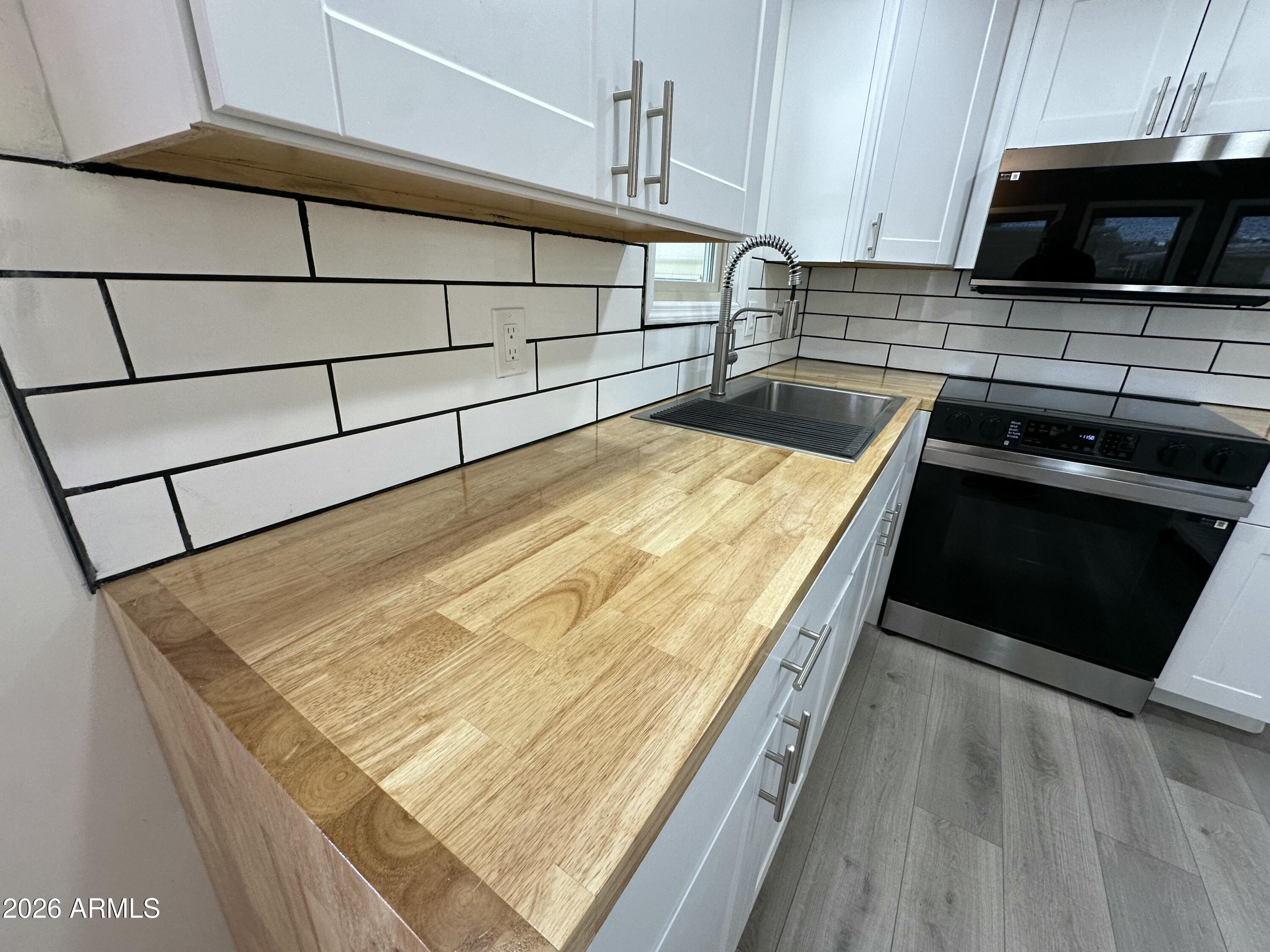 111 South Greenfield Road, Unit 575 Mesa, AZ 85206 - Photo 8 of 14 a kitchen with kitchen island a stove and a wooden floor