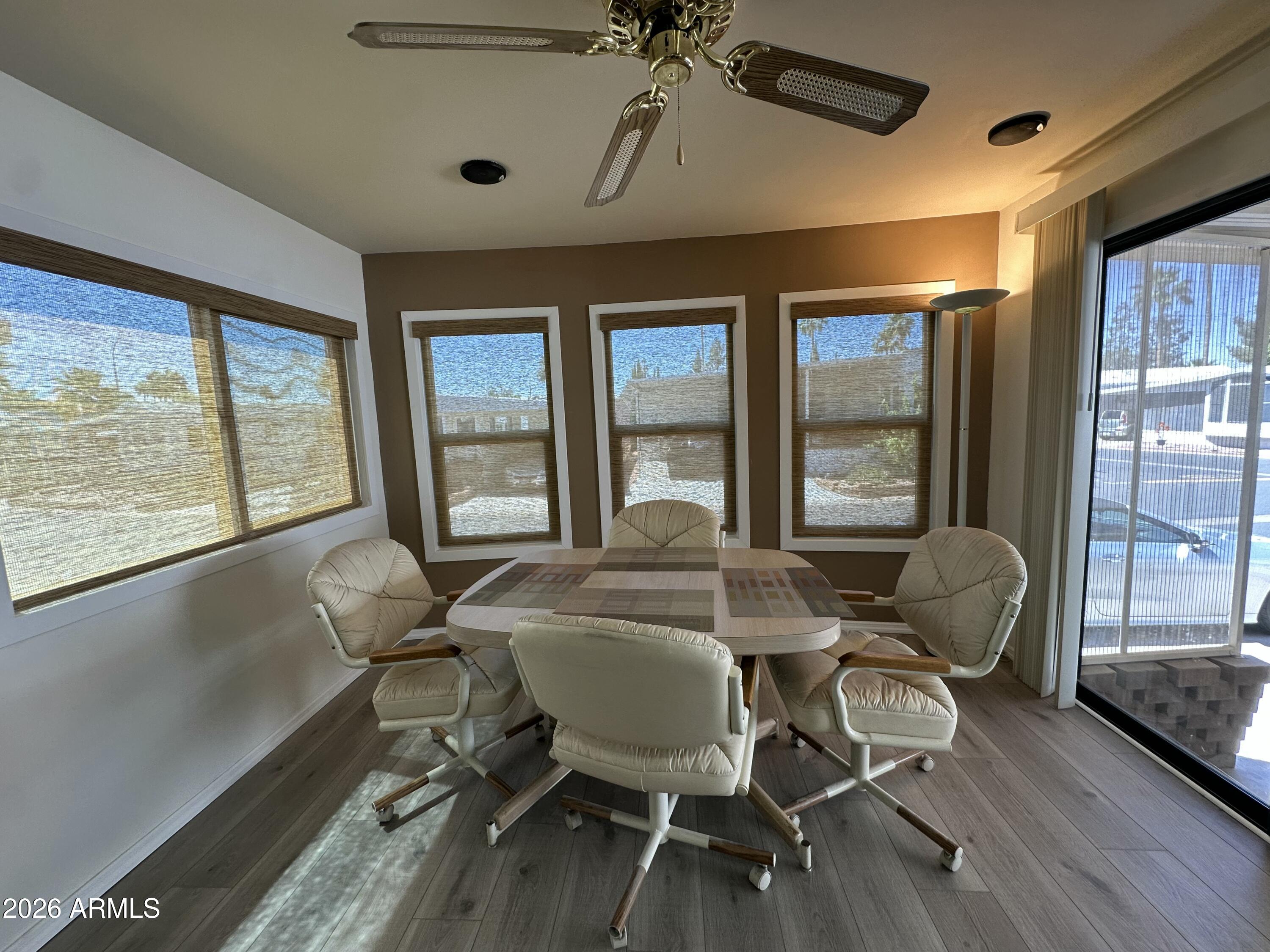 111 South Greenfield Road, Unit 575 Mesa, AZ 85206 - Photo 9 of 14 a dining room with furniture a chandelier and wooden floor