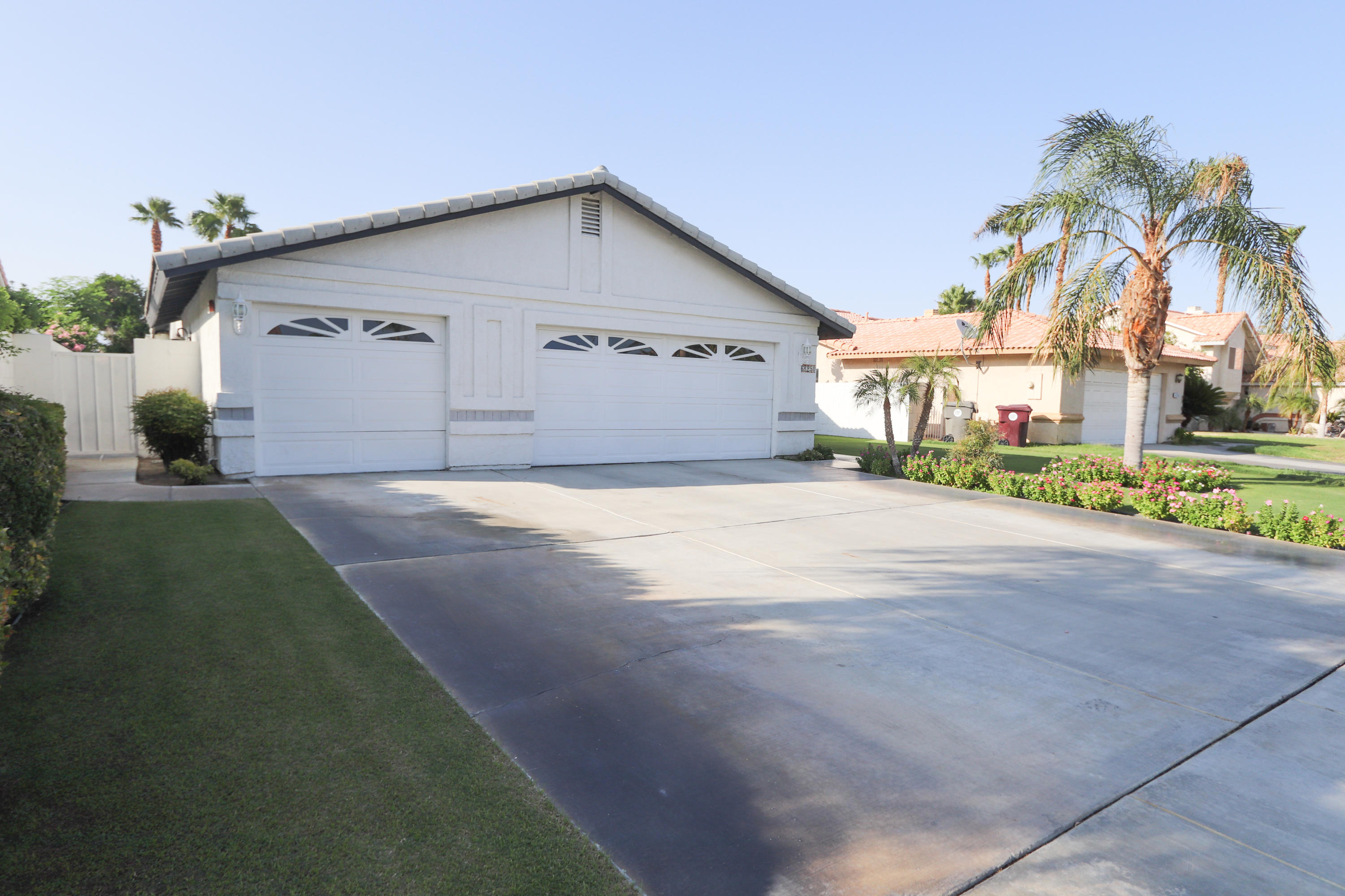 68250 Risueno Road Cathedral City, CA 92234 - Photo 15 of 19 a view of a house with a yard and palm trees