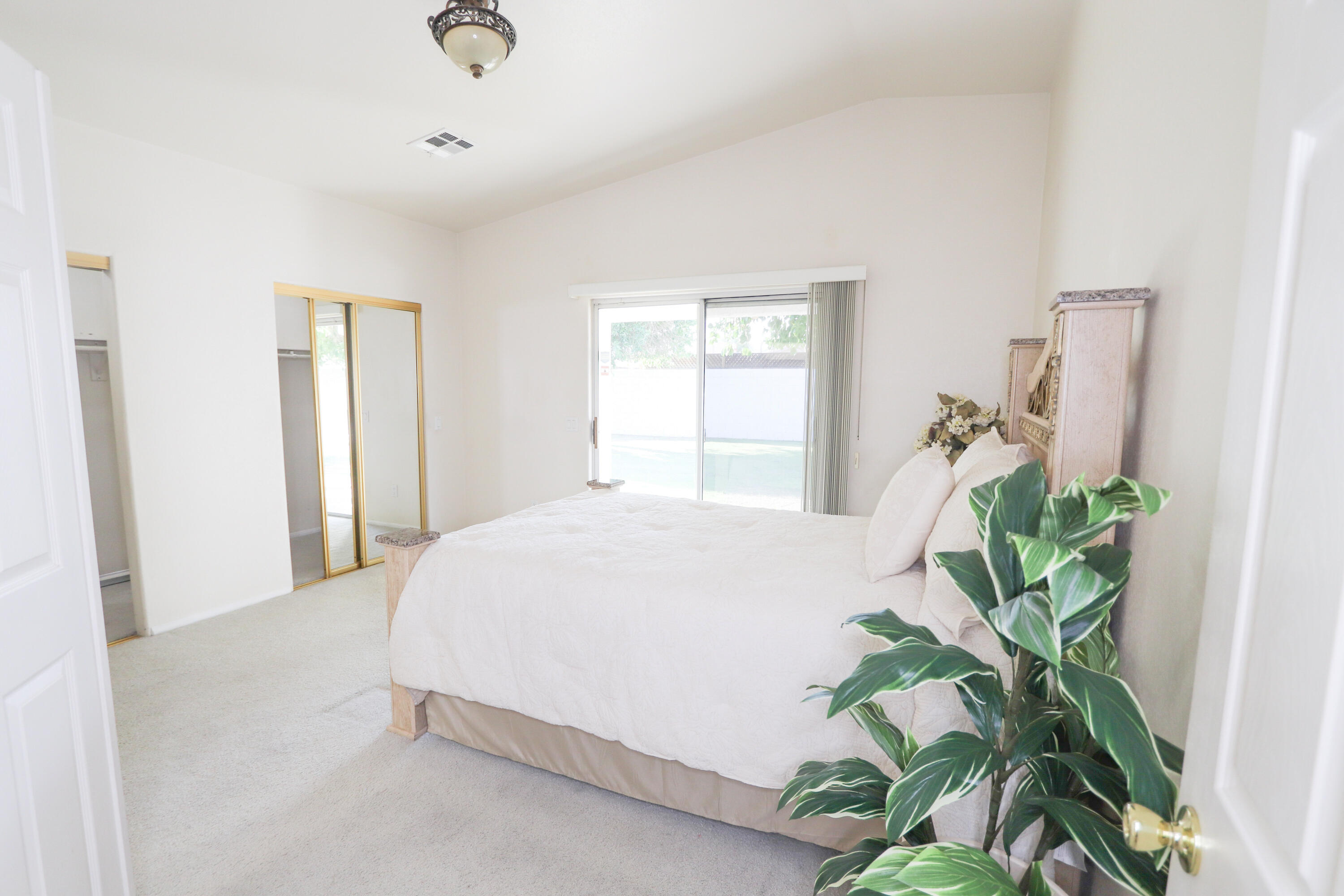 68250 Risueno Road Cathedral City, CA 92234 - Photo 17 of 19 a bed sitting in a spacious bedroom next to a window and a potted plant