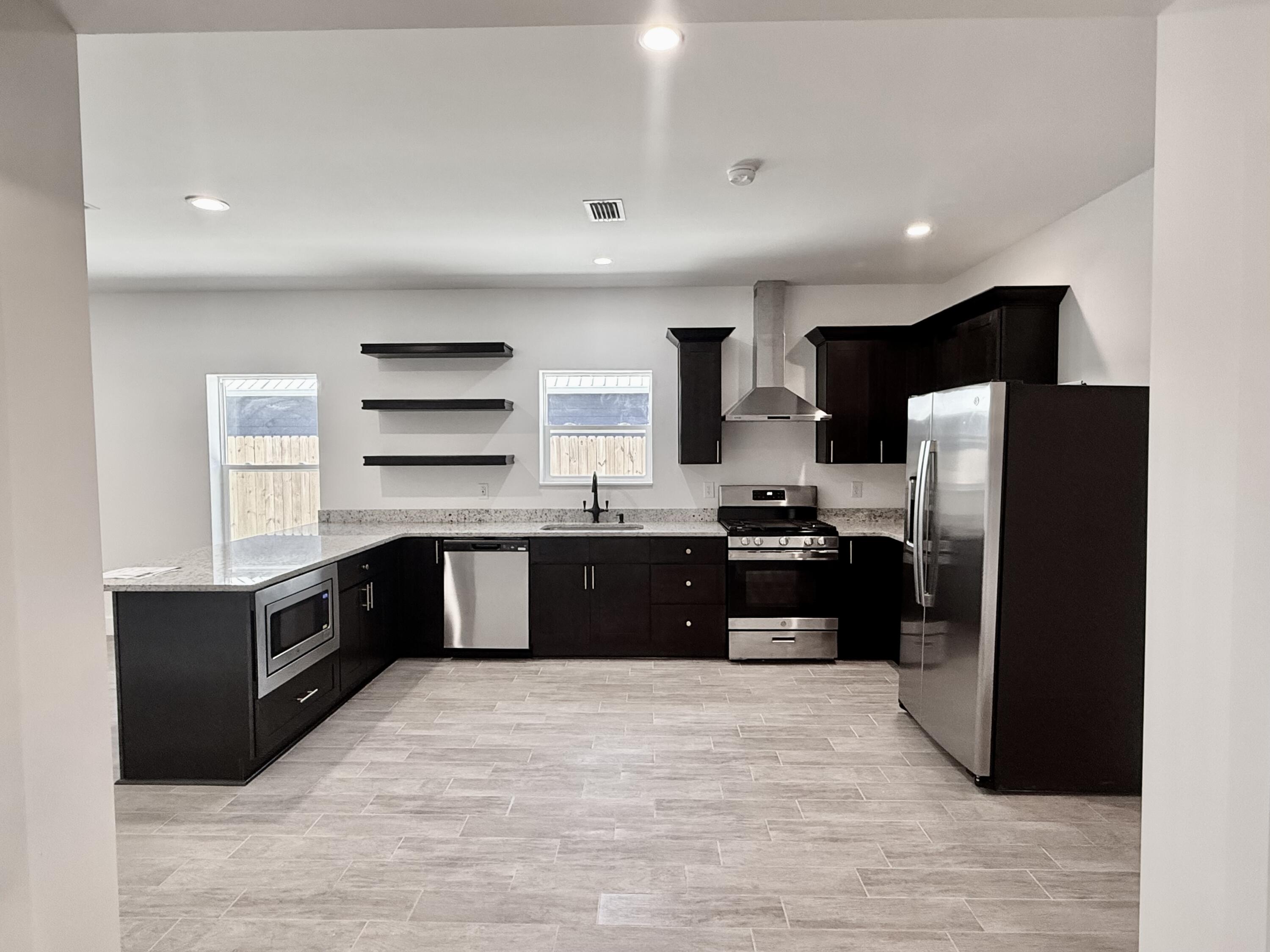 874 West Orange Avenue DeFuniak Springs, FL 32435 - Photo 10 of 32 a kitchen with stainless steel appliances granite countertop a refrigerator and a stove top oven