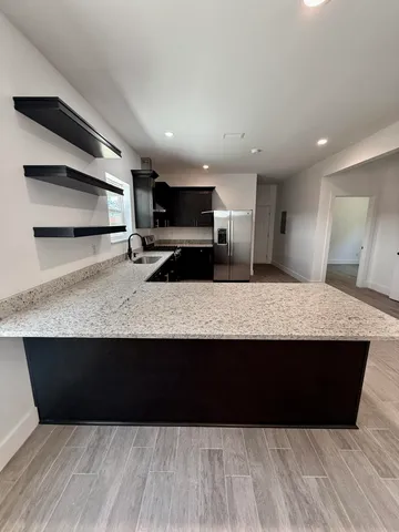 a bathroom with a shower and a tiled wall