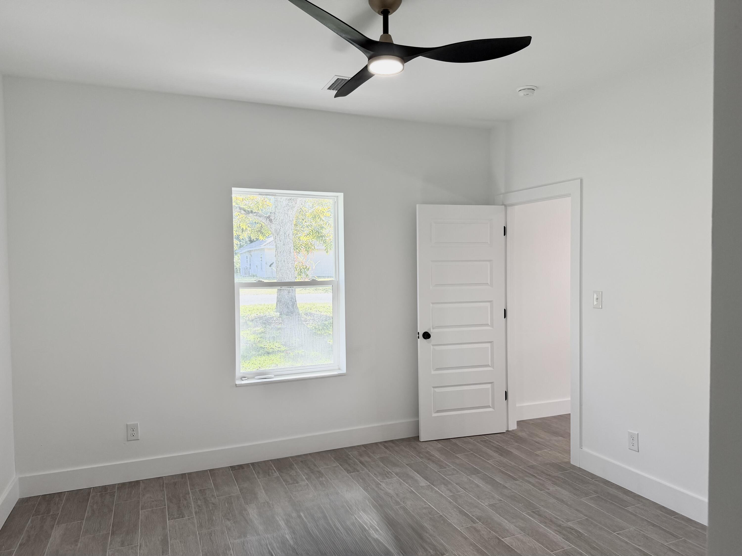 874 West Orange Avenue DeFuniak Springs, FL 32435 - Photo 15 of 32 an empty room with wooden floor cabinet and windows
