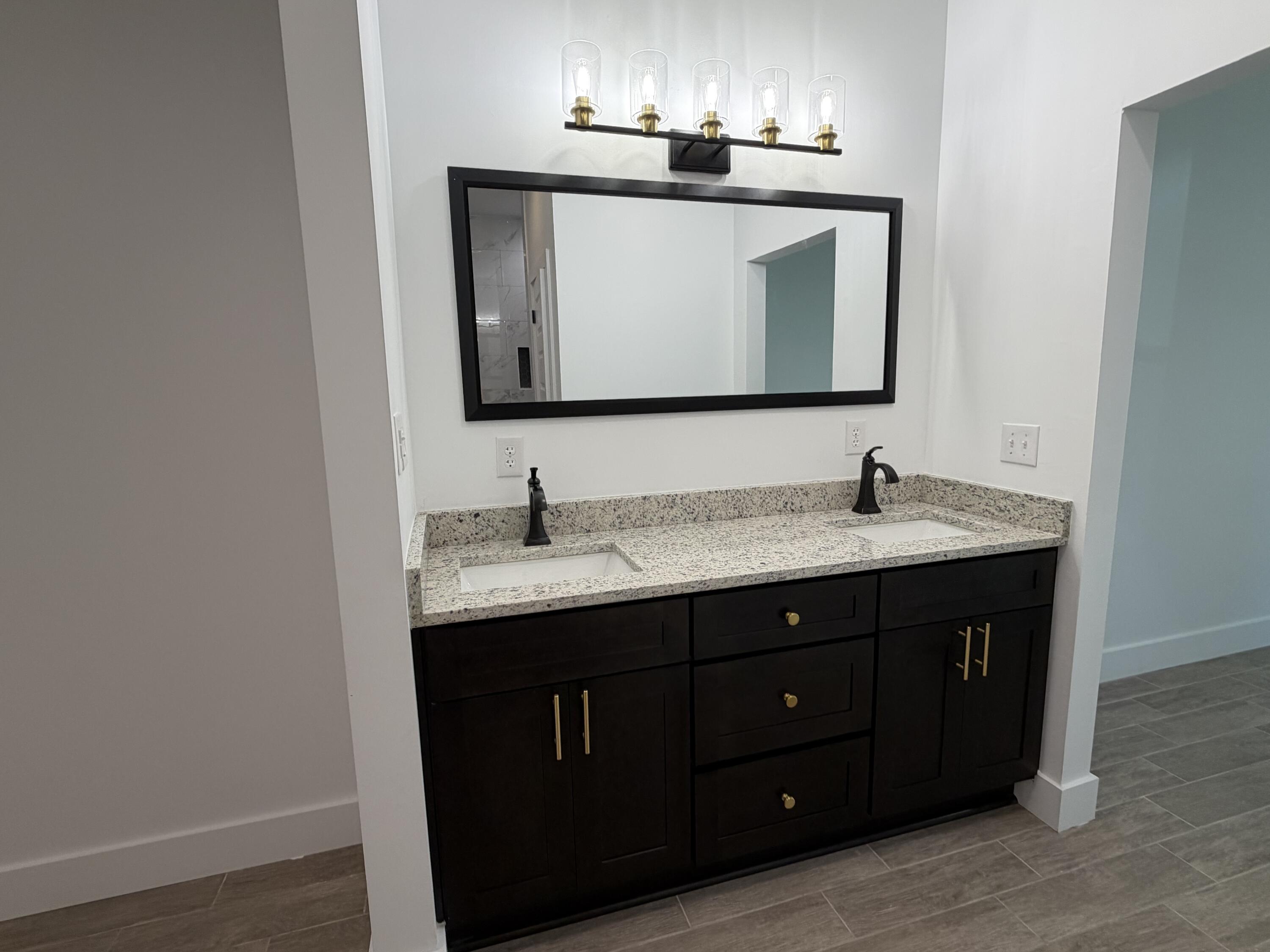 874 West Orange Avenue DeFuniak Springs, FL 32435 - Photo 17 of 32 a bathroom with a double vanity sink and mirror