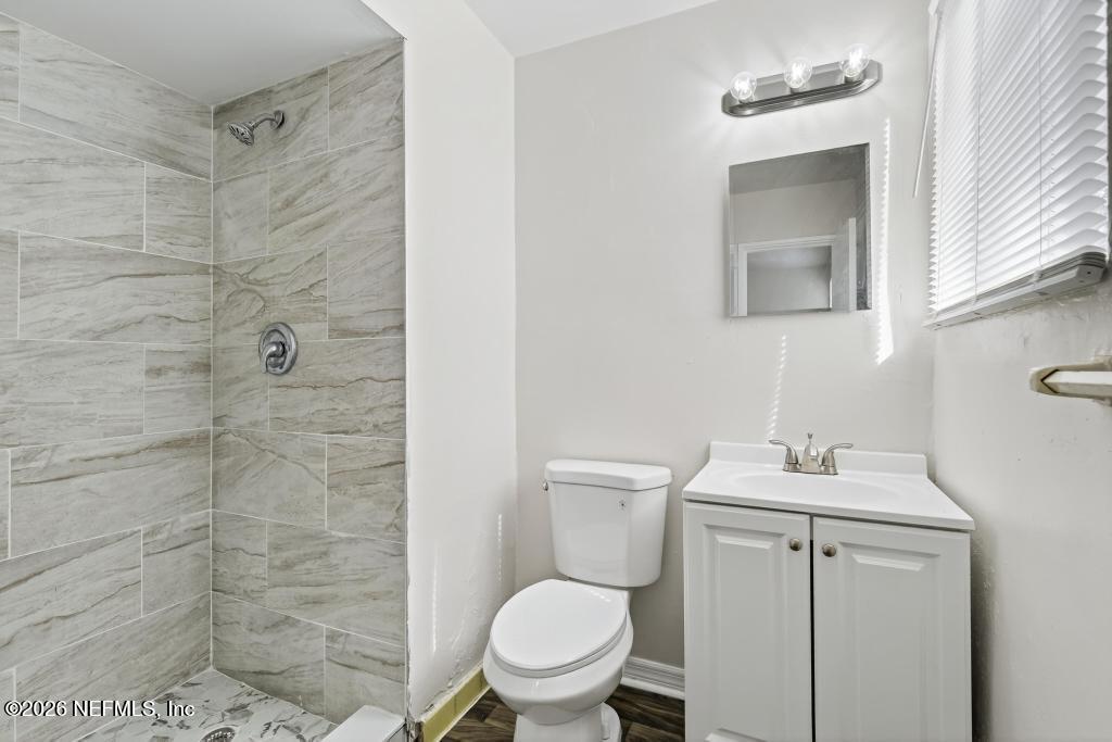 3024 Kline Road Jacksonville, FL 32246 - Photo 10 of 25 a bathroom with a toilet sink vanity and shower