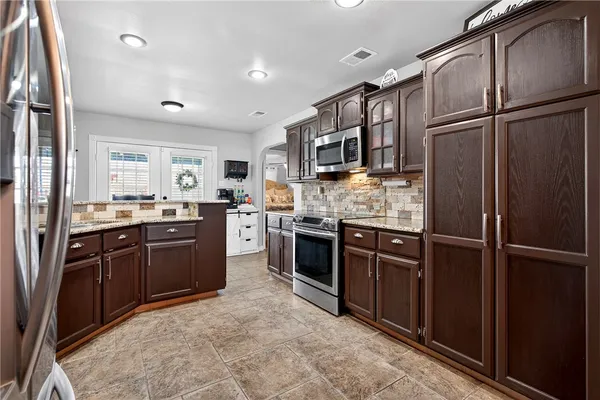 a kitchen with stainless steel appliances granite countertop a refrigerator stove and sink