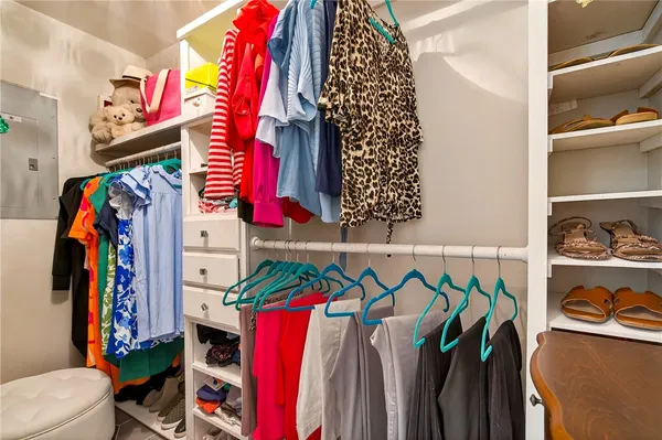 a view of walk in closet with clothes and shoes